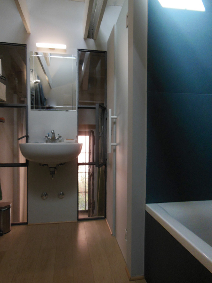 Photo of a small modern family bathroom in Milan with blue tiles, porcelain tiles, blue walls, porcelain flooring, a wall-mounted sink, grey floors, a single sink and exposed beams.