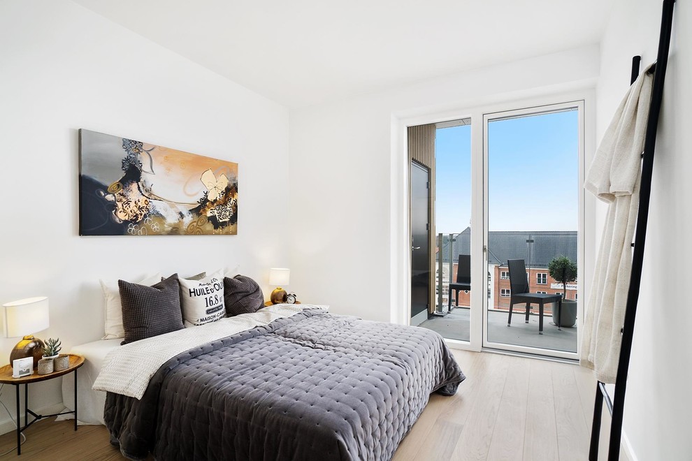 Design ideas for a mid-sized scandinavian master bedroom in Copenhagen with white walls, beige floor and light hardwood floors.