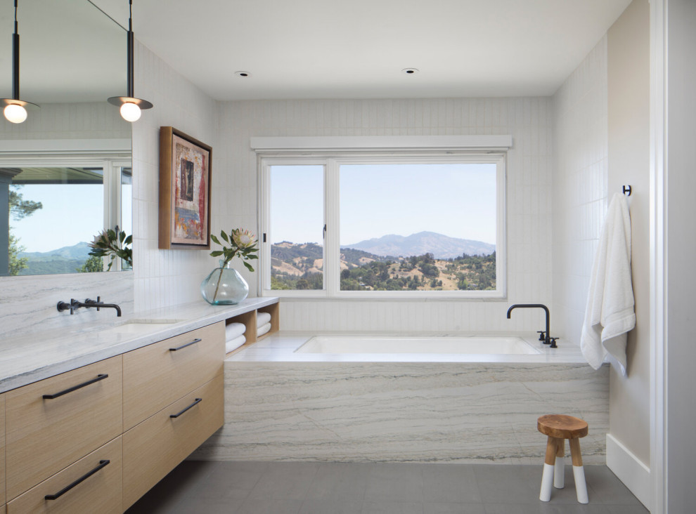 Aménagement d'une salle de bain blanche et bois contemporaine avec un carrelage blanc, un mur beige, un sol gris, un plan de toilette blanc et meuble simple vasque.