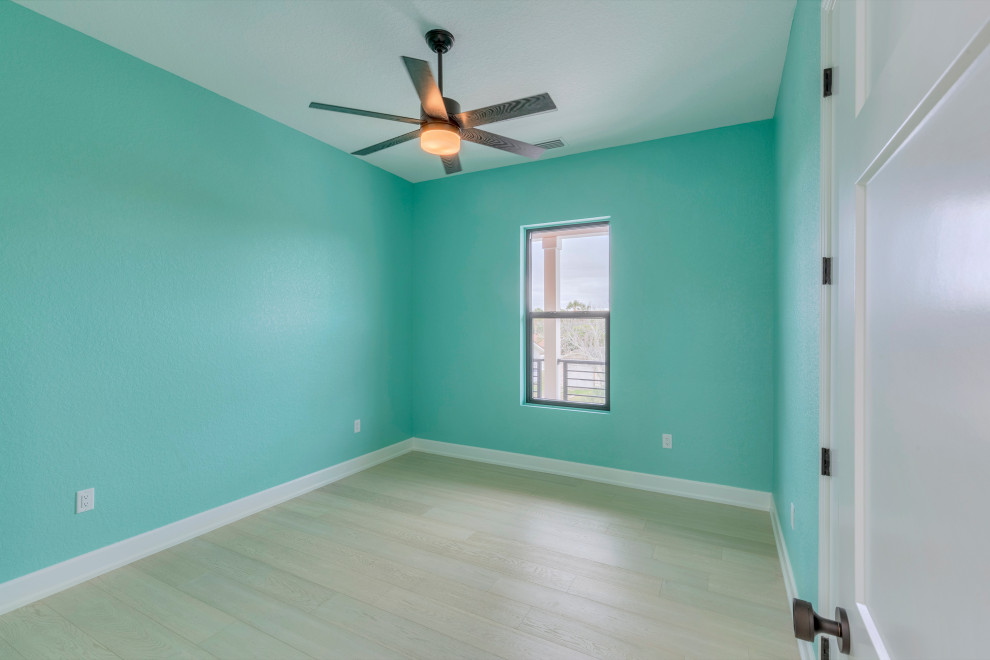 Idee per un'ampia camera da letto minimalista con pareti blu, pavimento in cemento e pavimento grigio