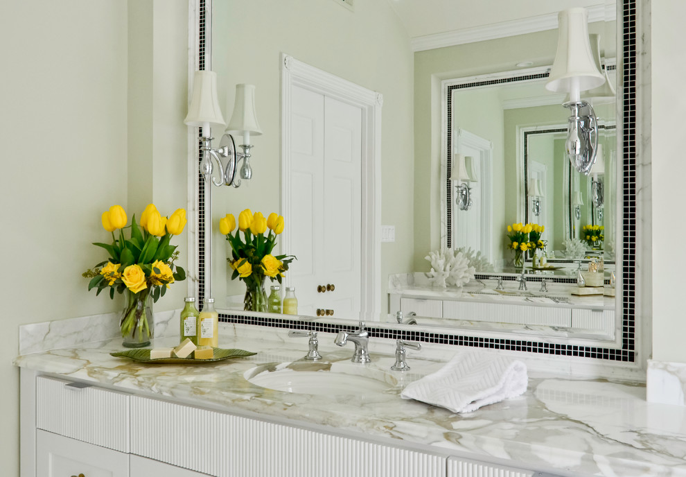 This is an example of a traditional master bathroom in New York with beaded inset cabinets, white cabinets, marble benchtops, a freestanding tub, multi-coloured tile, stone tile and marble floors.