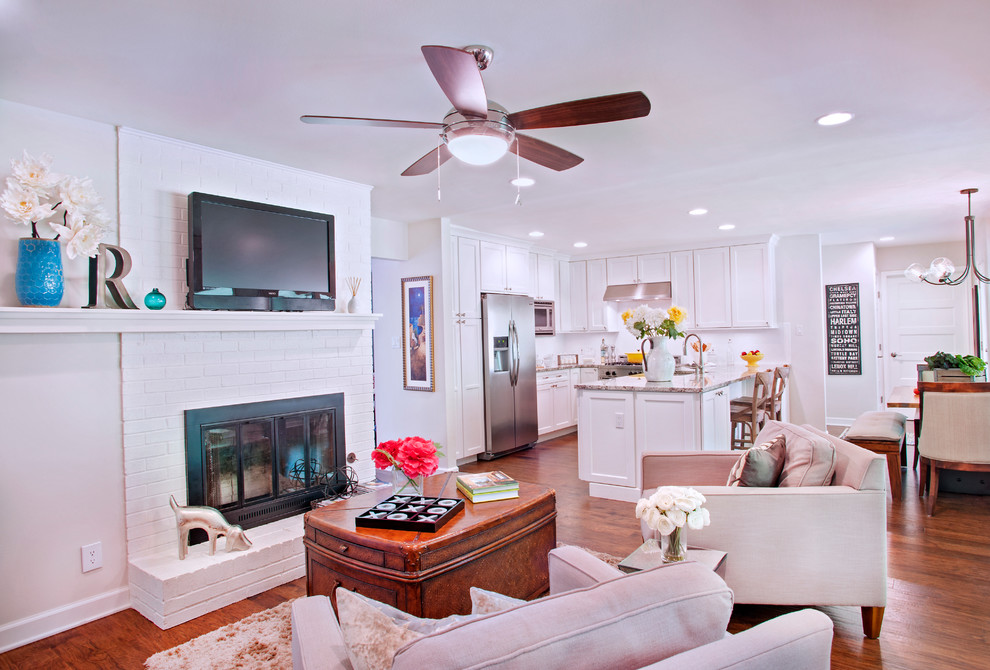 Example of a mid-sized transitional u-shaped medium tone wood floor eat-in kitchen design in Austin with a single-bowl sink, shaker cabinets, white cabinets, granite countertops, white backsplash, subway tile backsplash, stainless steel appliances and a peninsula