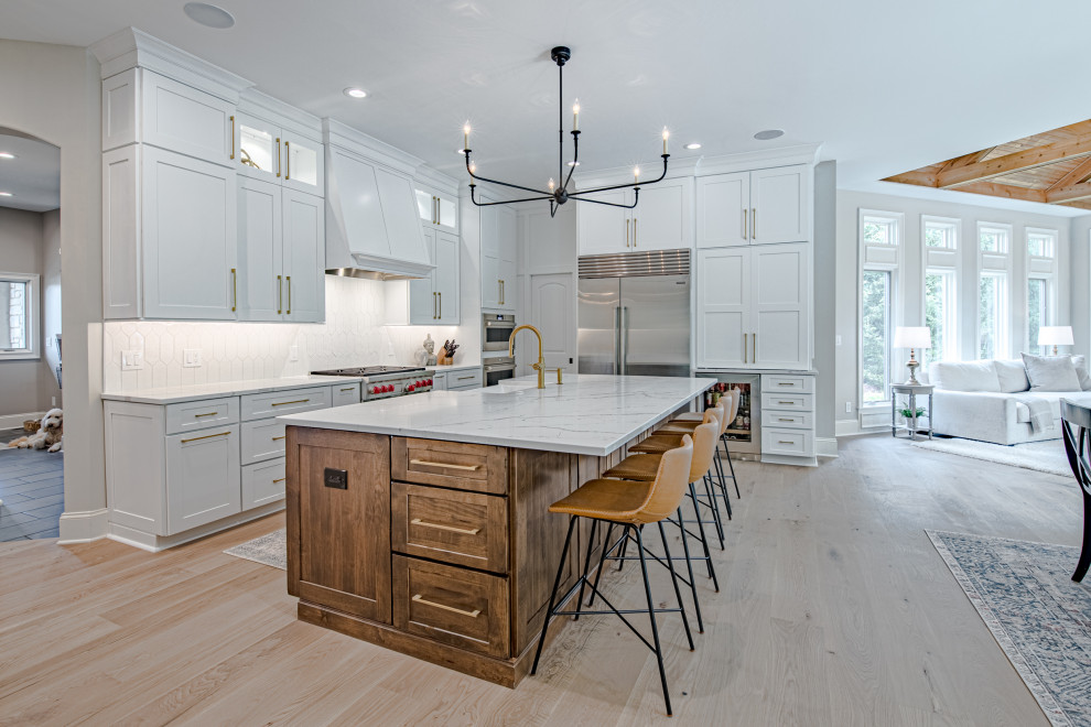 Large modern l-shaped eat-in kitchen in Cleveland with a farmhouse sink, flat-panel cabinets, medium wood cabinets, quartz benchtops, white splashback, ceramic splashback, stainless steel appliances, light hardwood floors, with island and yellow benchtop.