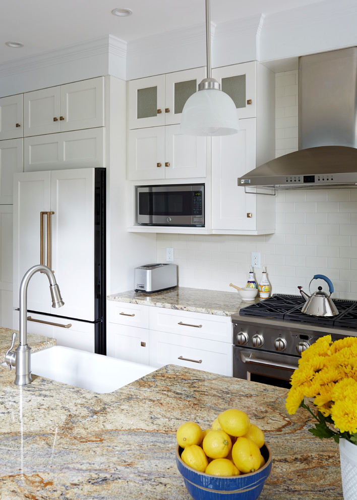 Inspiration for a transitional medium tone wood floor eat-in kitchen remodel in DC Metro with a farmhouse sink, recessed-panel cabinets, white cabinets, granite countertops, white backsplash, subway tile backsplash, stainless steel appliances and an island