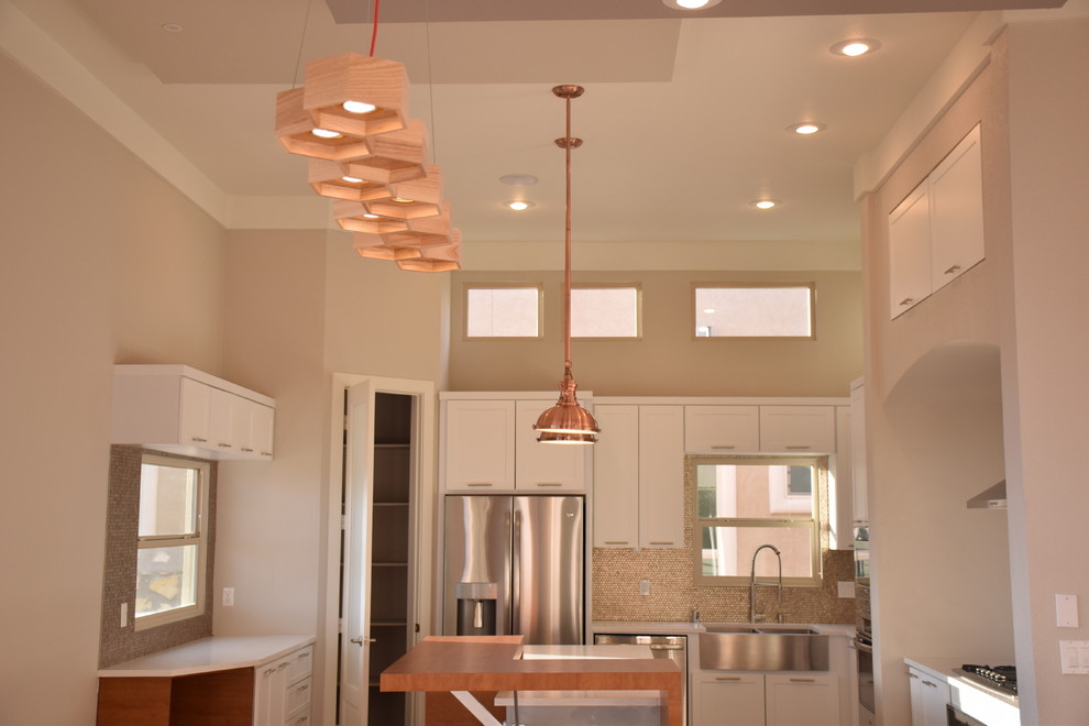 Example of a large transitional u-shaped home design design in Austin with a farmhouse sink, flat-panel cabinets, white cabinets, quartzite countertops, metallic backsplash, metal backsplash, stainless steel appliances and an island