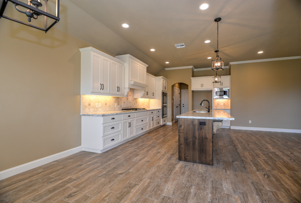 Inspiration for a transitional l-shaped ceramic tile open concept kitchen remodel in Austin with flat-panel cabinets, white cabinets, granite countertops, stone tile backsplash, stainless steel appliances and an island