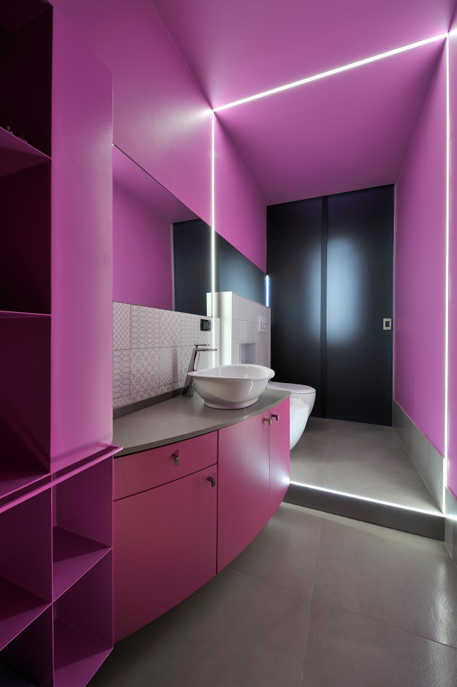 Design ideas for a small contemporary powder room in Other with a two-piece toilet, pink walls, a vessel sink, grey floor, grey benchtops and a floating vanity.