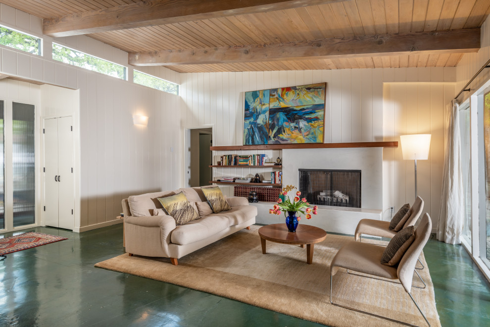This is an example of an expansive midcentury open concept living room in San Francisco with white walls, concrete floors, a standard fireplace, green floor, exposed beam, wood, planked wall panelling, a plaster fireplace surround and no tv.