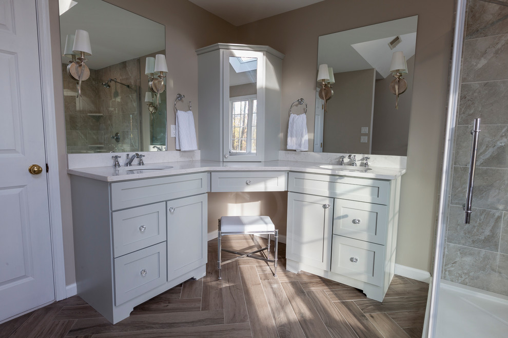 Example of a mid-sized transitional master gray tile and porcelain tile porcelain tile and gray floor freestanding bathtub design in New York with flat-panel cabinets, gray cabinets, a two-piece toilet, gray walls, an undermount sink, quartz countertops and a hinged shower door
