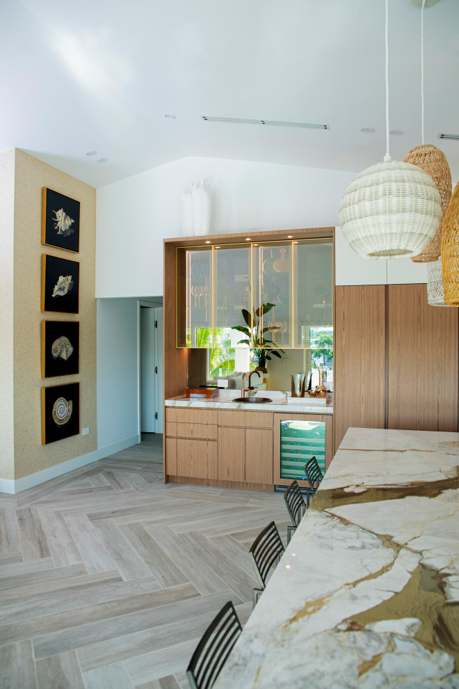 Foto på ett mellanstort funkis beige kök, med en undermonterad diskho, släta luckor, skåp i mellenmörkt trä, marmorbänkskiva, vitt stänkskydd, stänkskydd i marmor, integrerade vitvaror, klinkergolv i keramik, en köksö och brunt golv