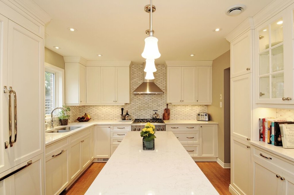 Inspiration for a mid-sized transitional l-shaped medium tone wood floor kitchen remodel in Ottawa with a double-bowl sink, recessed-panel cabinets, white cabinets, quartz countertops, gray backsplash, stone tile backsplash, stainless steel appliances and an island
