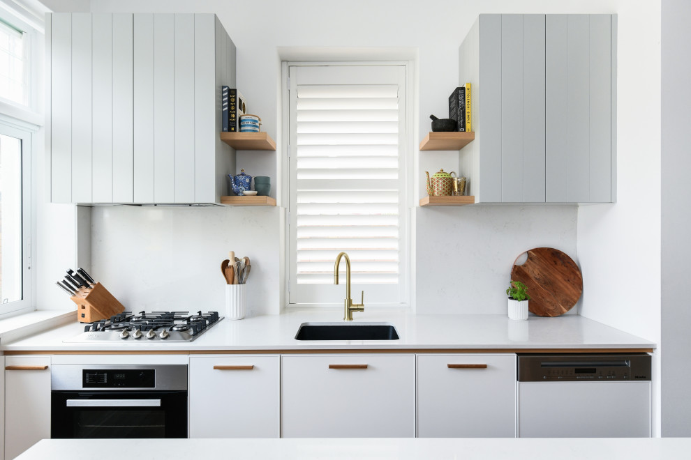 Inspiration for a mid-sized beach style galley kitchen pantry in Sydney with a double-bowl sink, grey cabinets, quartz benchtops, white splashback, panelled appliances, with island and white benchtop.