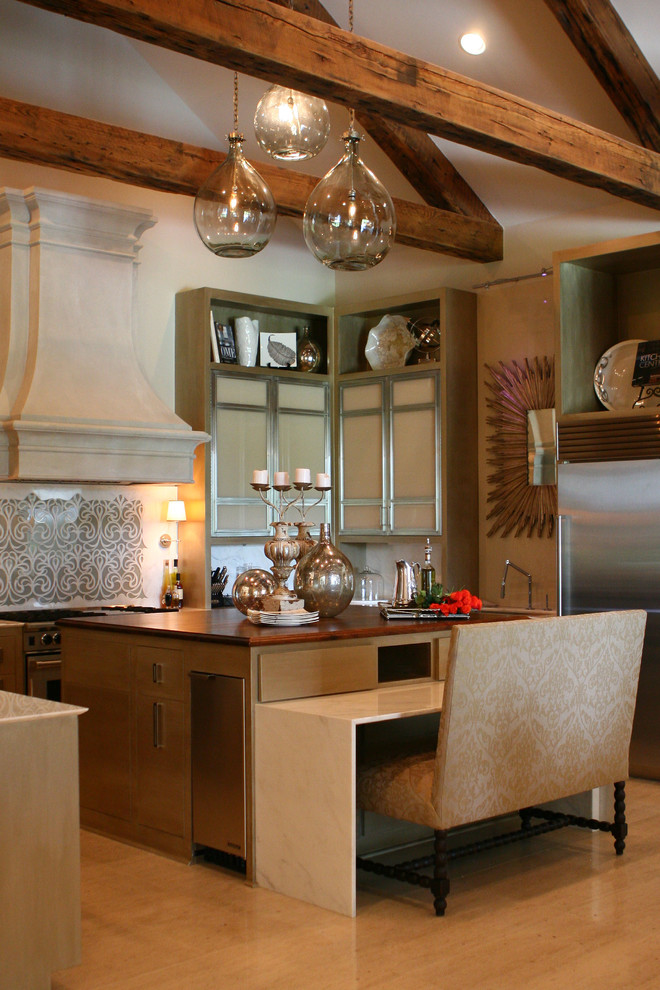 Example of a large transitional limestone floor and beige floor eat-in kitchen design with glass-front cabinets, marble countertops, white backsplash, marble backsplash and an island