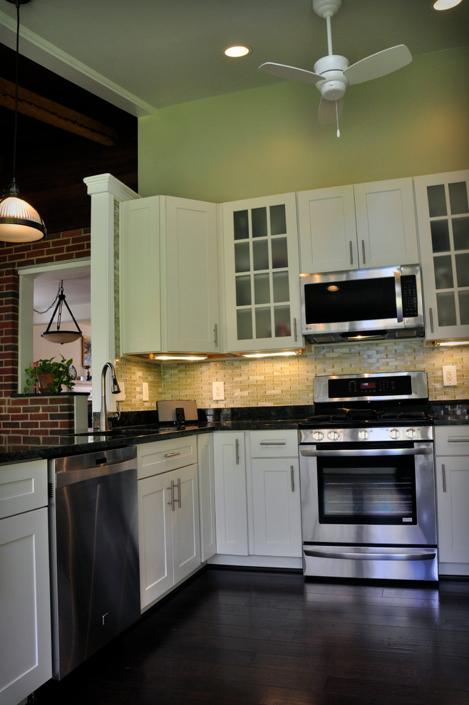 Eat-in kitchen - mid-sized transitional u-shaped dark wood floor eat-in kitchen idea in DC Metro with an undermount sink, shaker cabinets, white cabinets, granite countertops, yellow backsplash, glass tile backsplash, stainless steel appliances and a peninsula