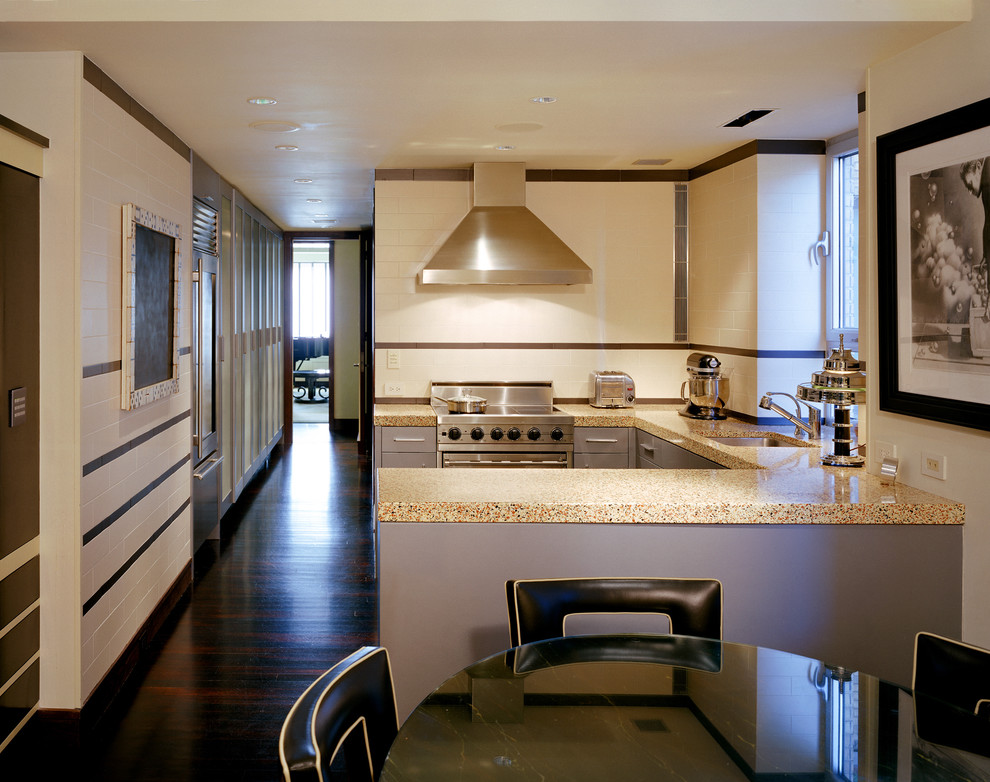 This is an example of a mid-sized eclectic u-shaped eat-in kitchen in New York with an undermount sink, flat-panel cabinets, grey cabinets, terrazzo benchtops, multi-coloured splashback, ceramic splashback, stainless steel appliances, dark hardwood floors, a peninsula, brown floor and multi-coloured benchtop.