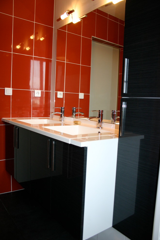 Mid-sized modern master bathroom in Rennes with beaded inset cabinets, black cabinets, an undermount tub, a shower/bathtub combo, a two-piece toilet, red tile, ceramic tile, white walls, ceramic floors, a console sink, black floor, a hinged shower door and white benchtops.