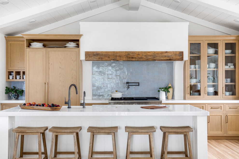Design ideas for a small beach style single-wall open plan kitchen in Orange County with shaker cabinets, light wood cabinets, quartz benchtops, blue splashback, terra-cotta splashback, panelled appliances, with island, white benchtop and vaulted.