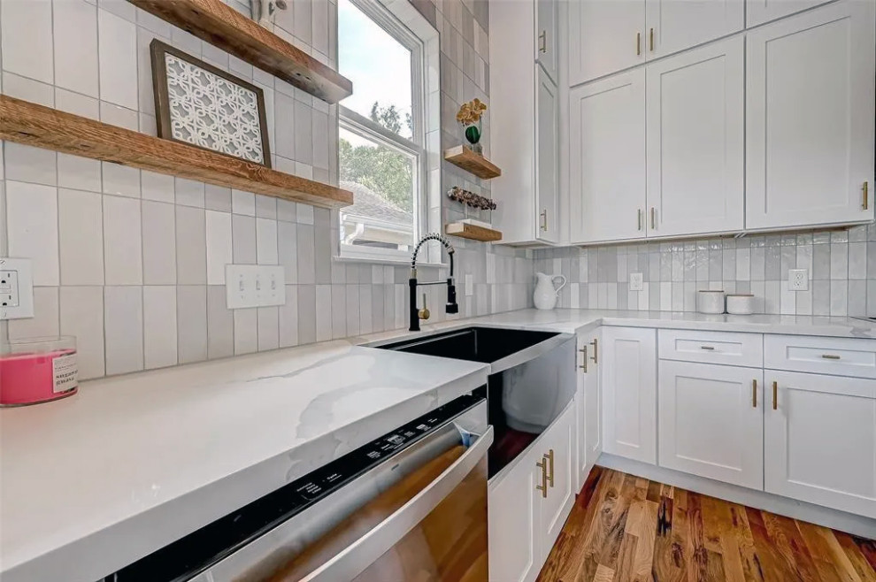 Large medium tone wood floor and brown floor kitchen photo with quartzite countertops, gray backsplash, ceramic backsplash and gray countertops
