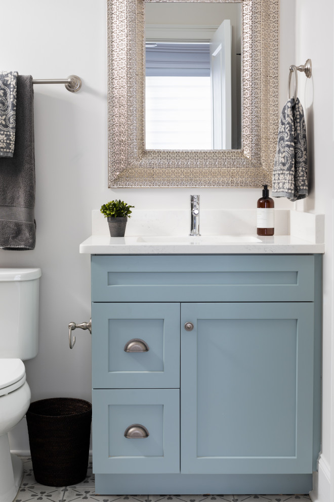 Photo of a traditional bathroom in Other with shaker cabinets, blue cabinets, a freestanding bath, white tiles, white walls, porcelain flooring, a submerged sink, engineered stone worktops, grey floors, white worktops, a single sink and a freestanding vanity unit.