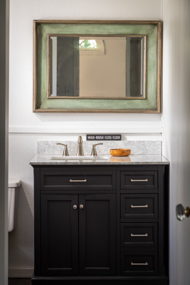 Photo of a medium sized shabby-chic style bathroom in New York with shaker cabinets, black cabinets, an alcove bath, a shower/bath combination, a two-piece toilet, white walls, a submerged sink, marble worktops, a shower curtain, white worktops, a single sink and a freestanding vanity unit.