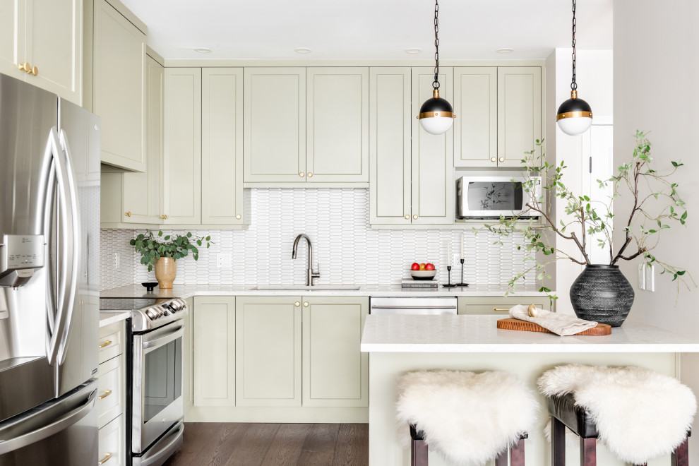 Inspiration for a small transitional brown floor kitchen remodel with shaker cabinets, green cabinets, white backsplash, stainless steel appliances, an island and white countertops