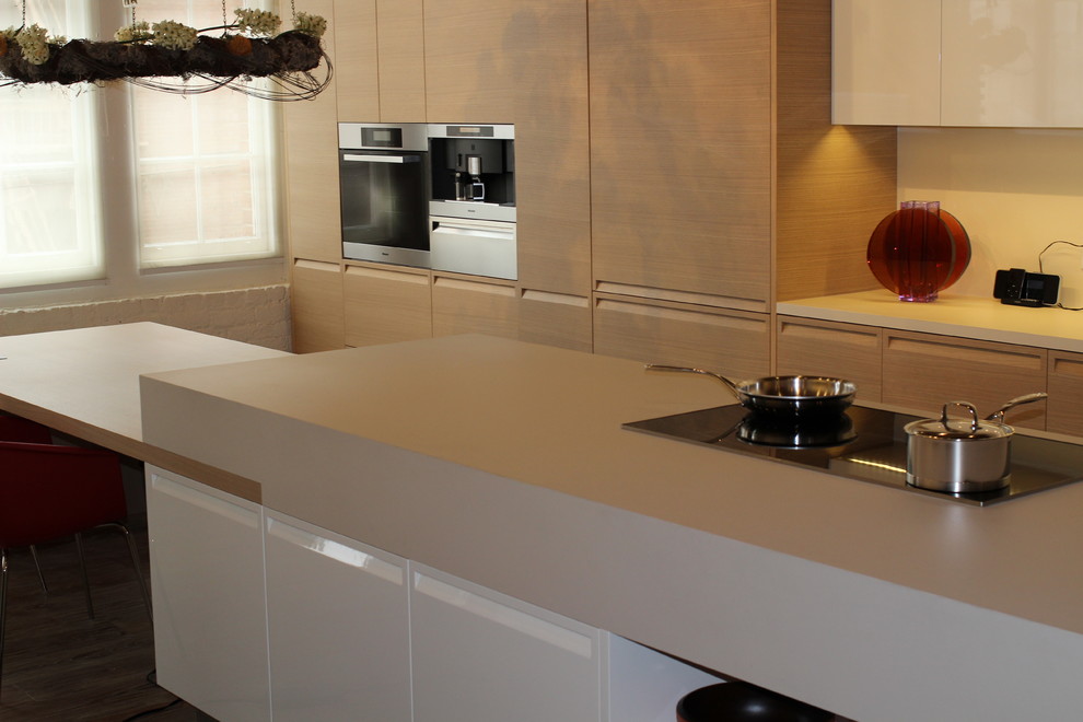 Foto på ett funkis linjärt kök och matrum, med en dubbel diskho, släta luckor, skåp i ljust trä, bänkskiva i koppar och rostfria vitvaror