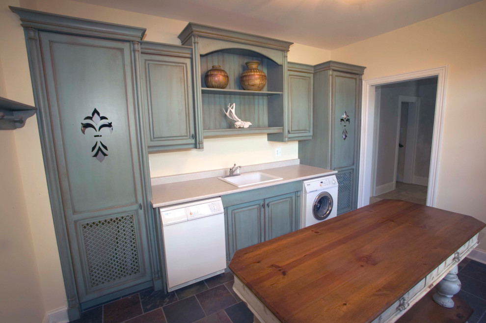 Large traditional single-wall dedicated laundry room in DC Metro with a drop-in sink, raised-panel cabinets, distressed cabinets and an integrated washer and dryer.