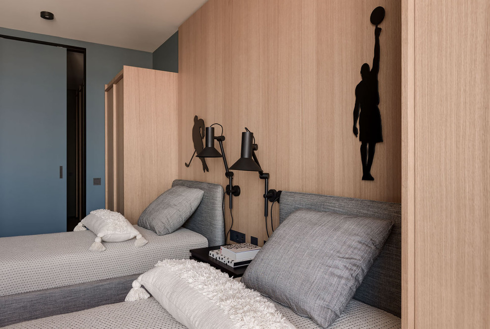 Foto på ett mellanstort skandinaviskt barnrum kombinerat med sovrum, med blå väggar, mellanmörkt trägolv och beiget golv