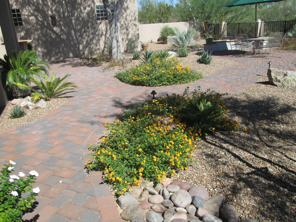 Design ideas for a mid-sized mediterranean backyard full sun xeriscape for summer in Phoenix with a garden path and brick pavers.