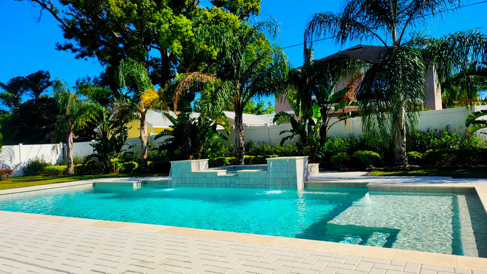 Immagine di una piscina monocorsia chic rettangolare dietro casa con una vasca idromassaggio e pavimentazioni in mattoni
