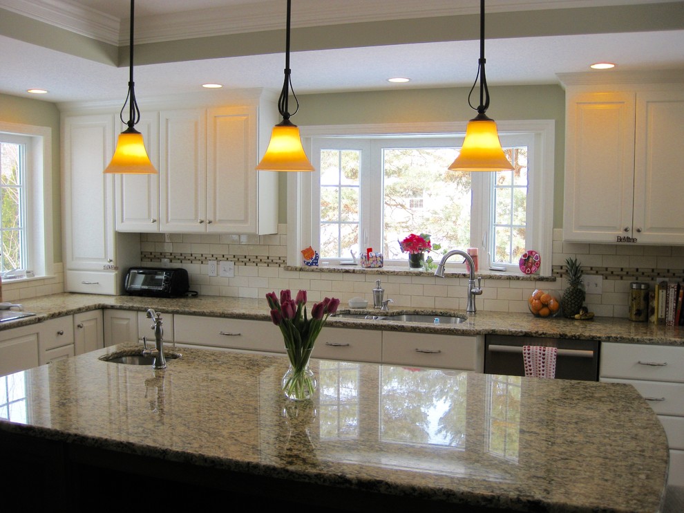 Inspiration for a transitional u-shaped medium tone wood floor eat-in kitchen remodel in Boston with an undermount sink, raised-panel cabinets, white cabinets, granite countertops, white backsplash, ceramic backsplash, stainless steel appliances, an island and beige countertops