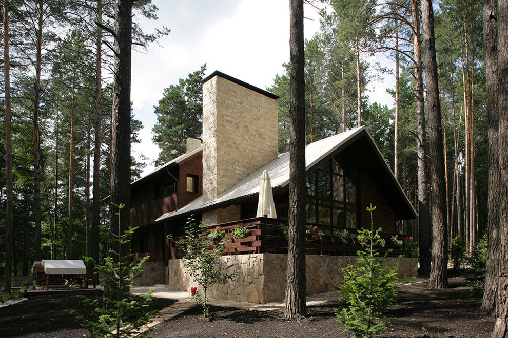 Mid-sized country three-storey brown exterior in Novosibirsk with wood siding and a gable roof.