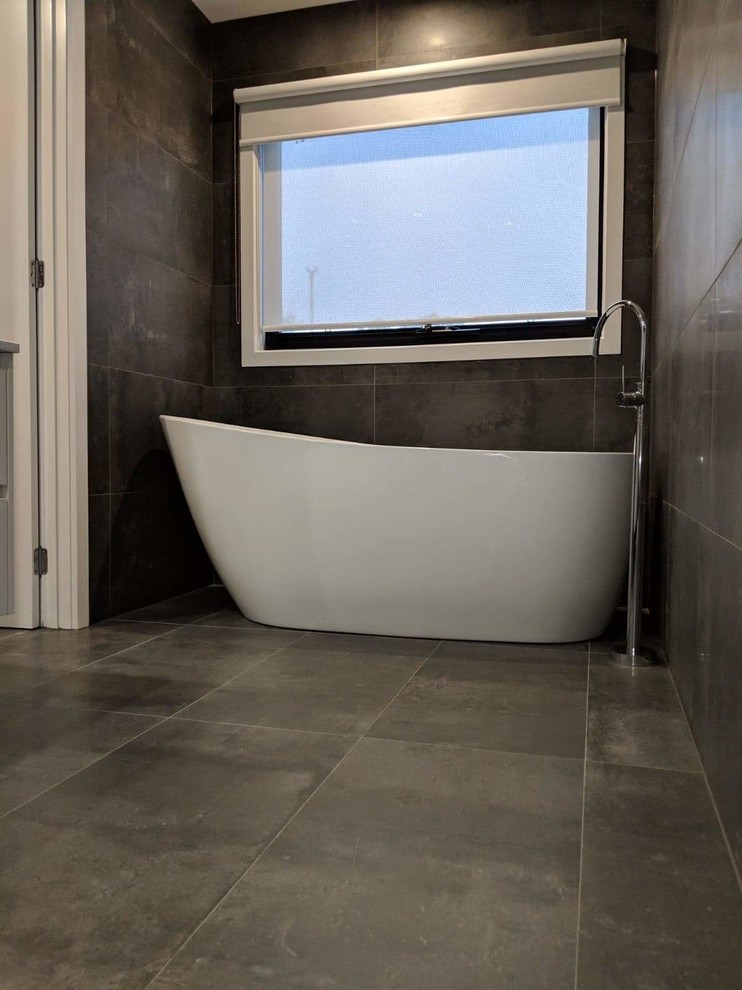 Mid-sized modern master bathroom in Melbourne with flat-panel cabinets, white cabinets, a freestanding tub, a double shower, gray tile, porcelain tile, beige walls, porcelain floors, a vessel sink, laminate benchtops, grey floor, an open shower and white benchtops.