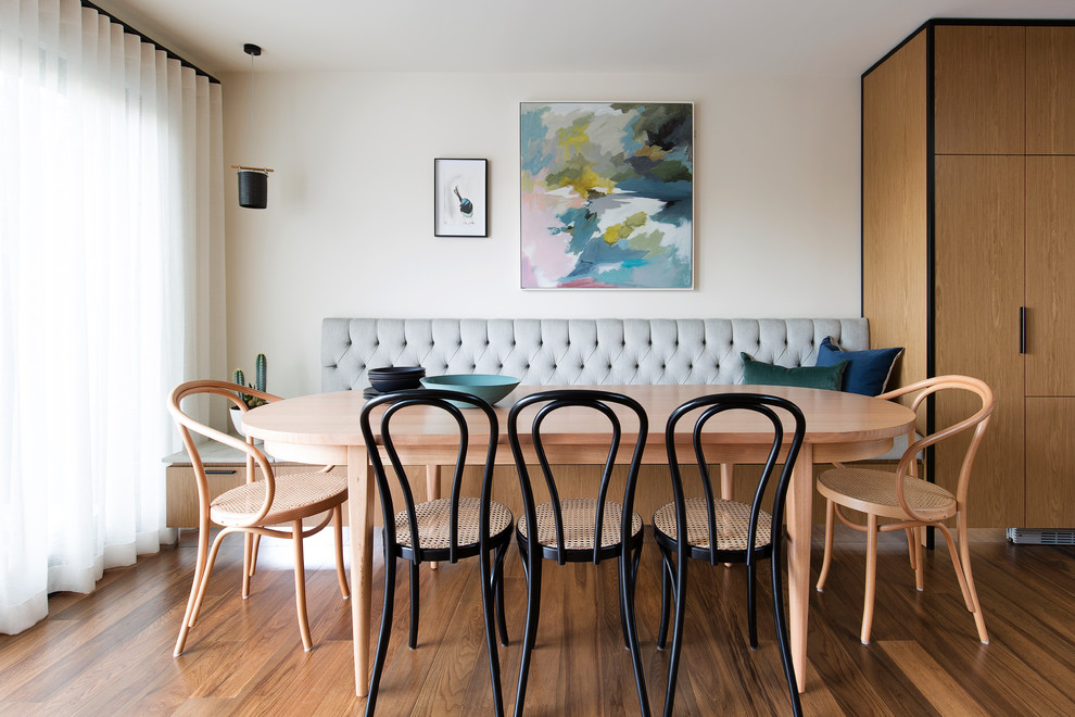 This is an example of a contemporary dining room in Sydney with white walls, dark hardwood floors and brown floor.