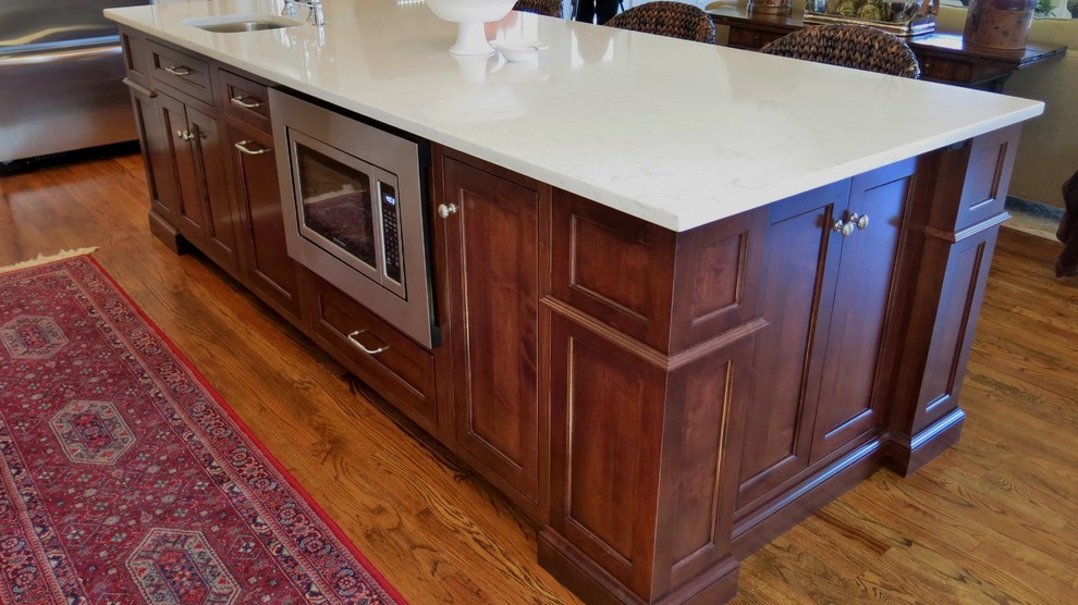 Transitional home design photo with white cabinets, quartz countertops and white backsplash