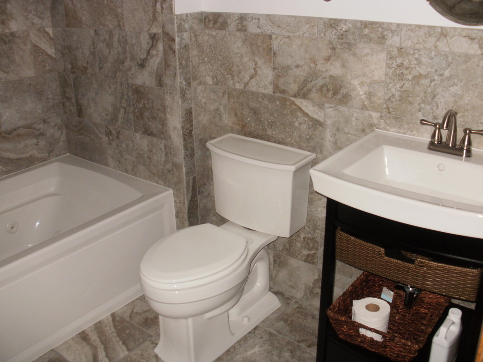 This is an example of a transitional bathroom in Minneapolis with a console sink, furniture-like cabinets, dark wood cabinets, marble benchtops, an alcove tub, an alcove shower, a two-piece toilet, gray tile and porcelain tile.