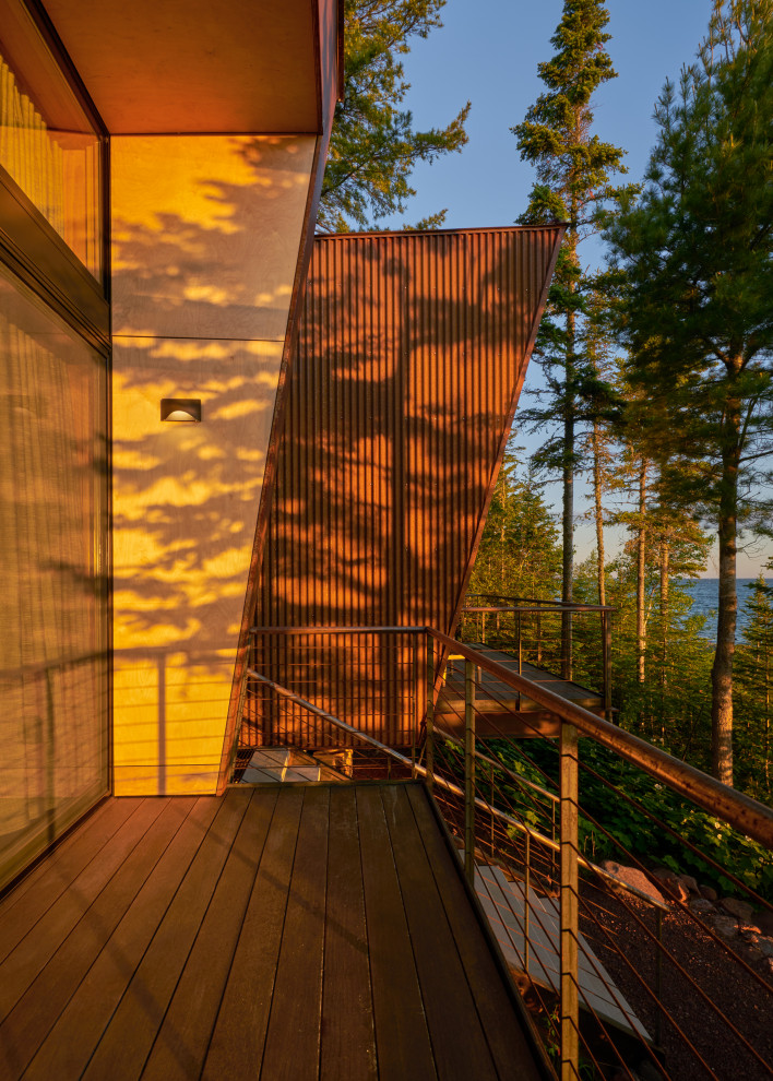 Mountain style backyard metal railing deck photo in Seattle with a roof extension