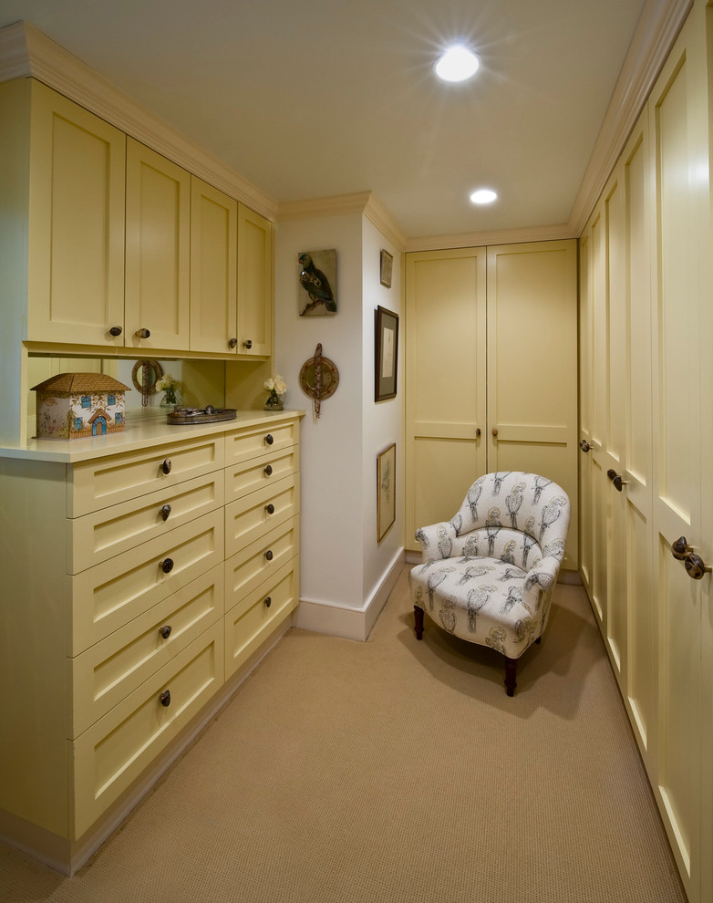 Inspiration for an expansive transitional women's walk-in wardrobe in Philadelphia with shaker cabinets, yellow cabinets, carpet and beige floor.