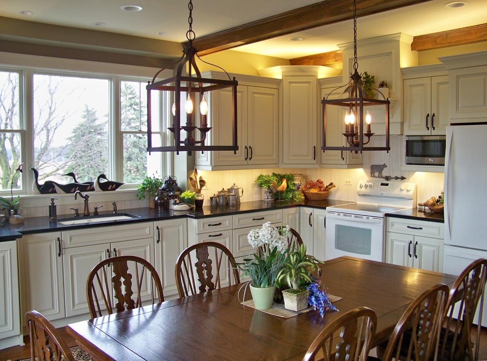 Inspiration for a mid-sized transitional l-shaped medium tone wood floor and brown floor eat-in kitchen remodel in Chicago with an undermount sink, raised-panel cabinets, white cabinets, solid surface countertops, white backsplash, wood backsplash, white appliances and no island