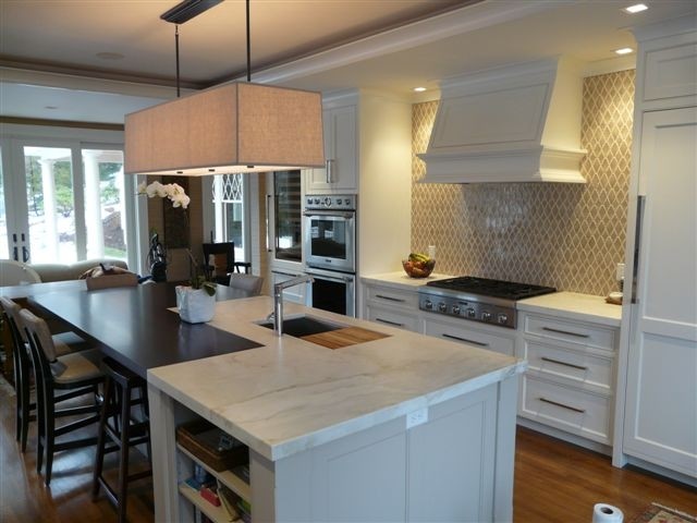 This is an example of a contemporary kitchen in Boston with marble benchtops and with island.