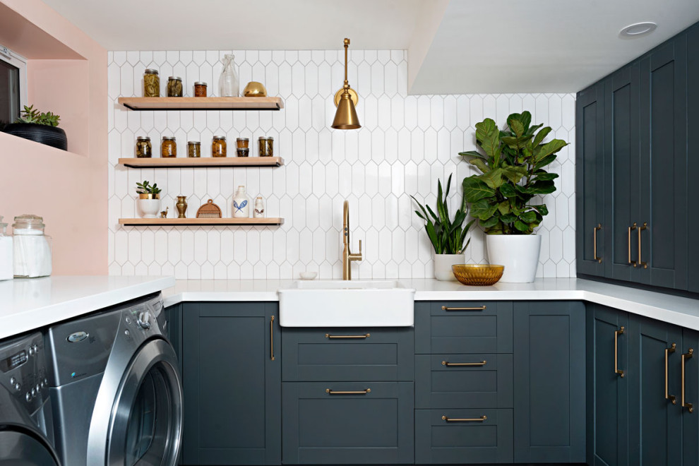 This is an example of a country laundry room in Toronto with a farmhouse sink, shaker cabinets, blue cabinets, quartz benchtops, linoleum floors, a side-by-side washer and dryer, grey floor and white benchtop.