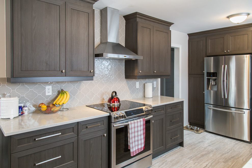 Inspiration for a mid-sized transitional galley porcelain tile and beige floor enclosed kitchen remodel in Toronto with an undermount sink, recessed-panel cabinets, dark wood cabinets, quartzite countertops, gray backsplash, ceramic backsplash, stainless steel appliances, no island and white countertops