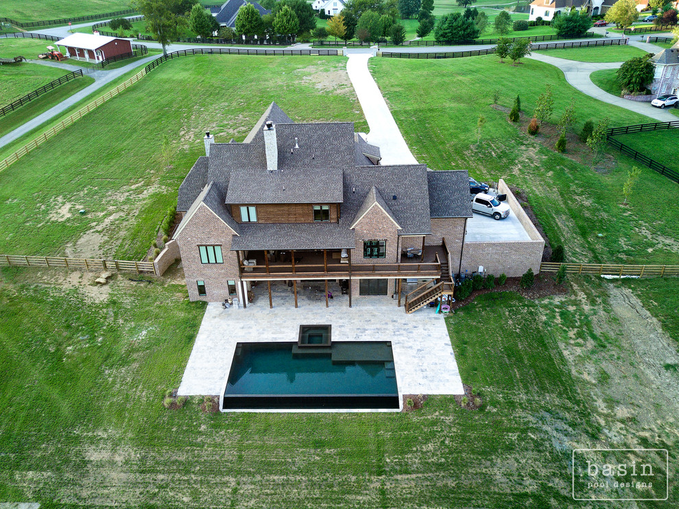 Hot tub - large transitional backyard stone and custom-shaped infinity hot tub idea in Nashville