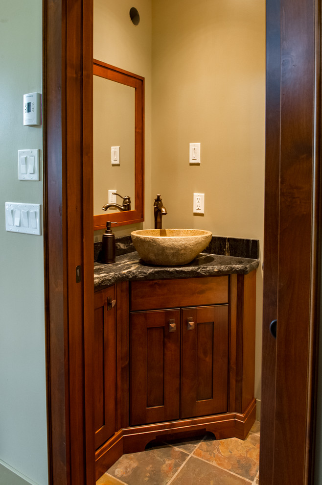 Inspiration for a small country powder room in Vancouver with shaker cabinets, dark wood cabinets, brown walls, slate floors, a vessel sink, granite benchtops and brown floor.