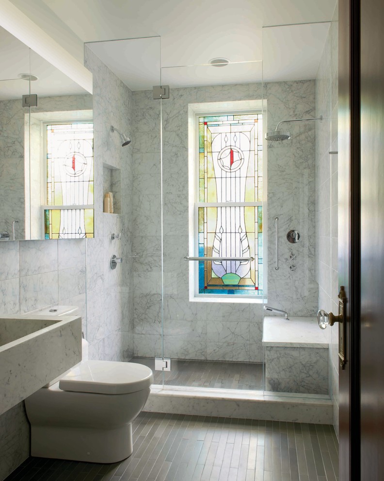 This is an example of a mid-sized contemporary 3/4 bathroom in New York with an integrated sink, an alcove shower, a two-piece toilet, gray tile, marble, grey walls, marble benchtops, a hinged shower door, grey benchtops and a shower seat.