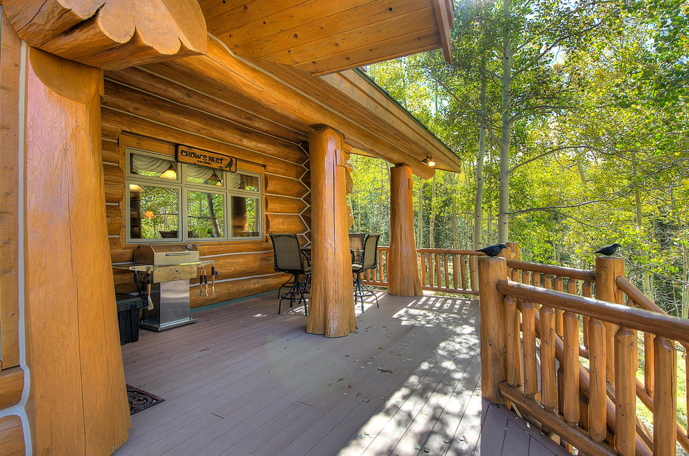 Deck - large rustic backyard deck idea in Denver with a roof extension