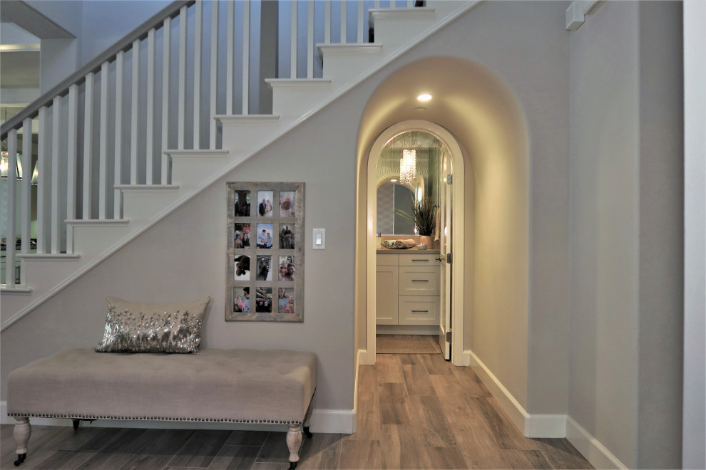 Large beach style foyer in Orange County with beige walls, porcelain floors and brown floor.