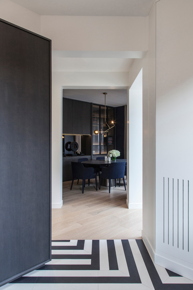 This is an example of a mid-sized contemporary separate dining room in Paris with white walls, light hardwood floors, no fireplace and beige floor.