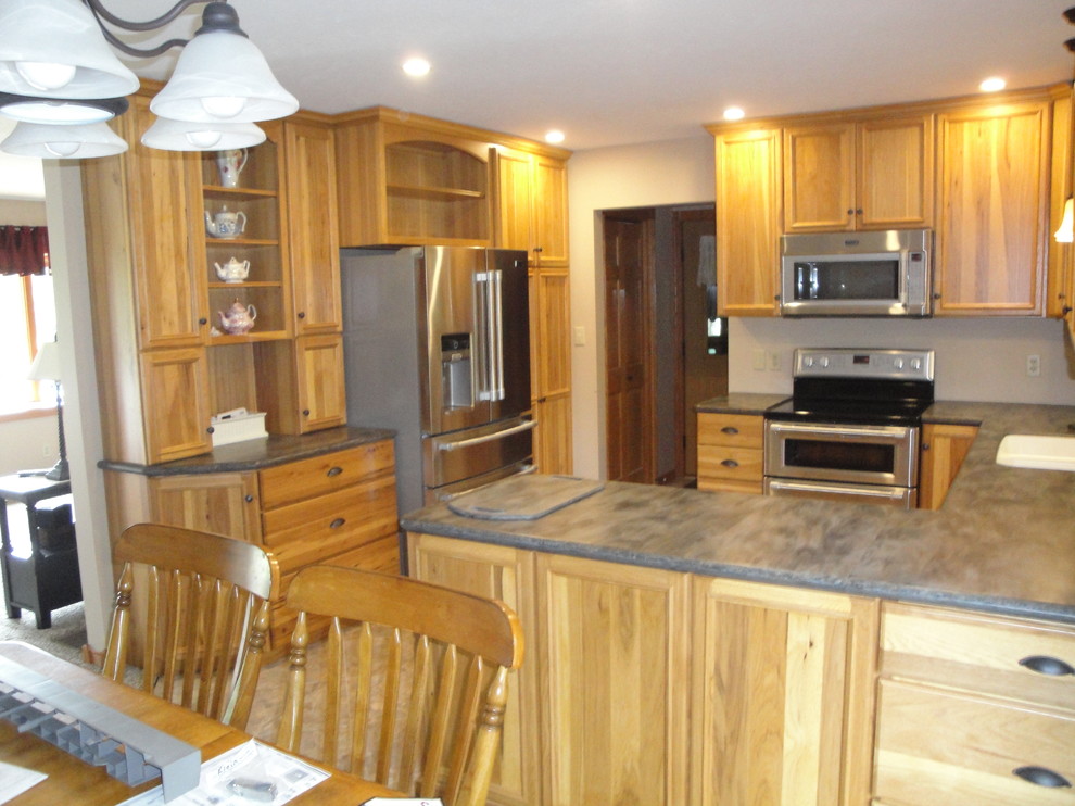Eat-in kitchen - mid-sized transitional u-shaped vinyl floor and beige floor eat-in kitchen idea with an undermount sink, flat-panel cabinets, light wood cabinets, solid surface countertops, stainless steel appliances, a peninsula and brown countertops