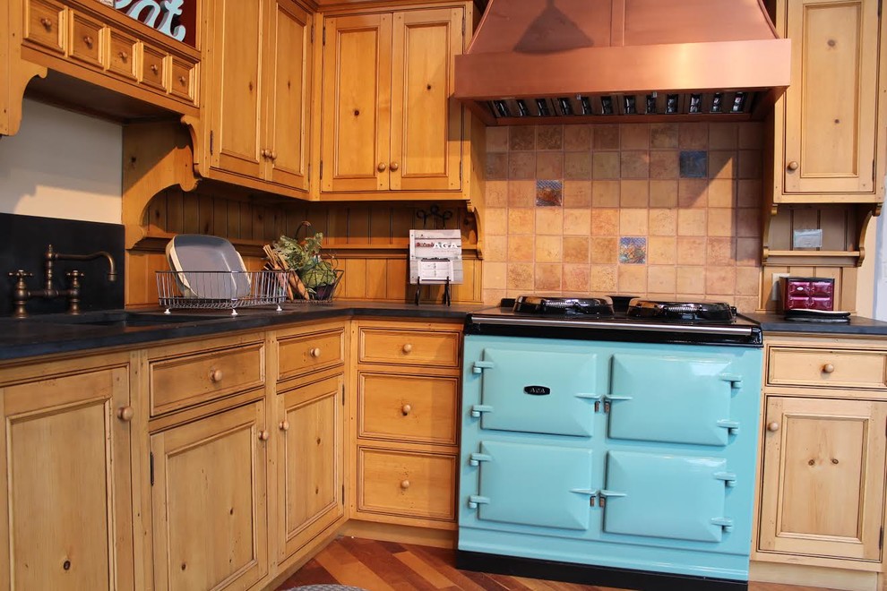 Inspiration for a mid-sized country l-shaped separate kitchen in Burlington with an undermount sink, recessed-panel cabinets, light wood cabinets, soapstone benchtops, beige splashback, ceramic splashback, medium hardwood floors, brown floor, coloured appliances and no island.